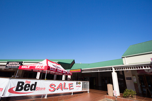 Hillcrest, South Africa - May 19, 2014: A bed sale at the Hillcrest Heritage Centre outside Durban. Towards the back is a Blockbusters video for hire shop.