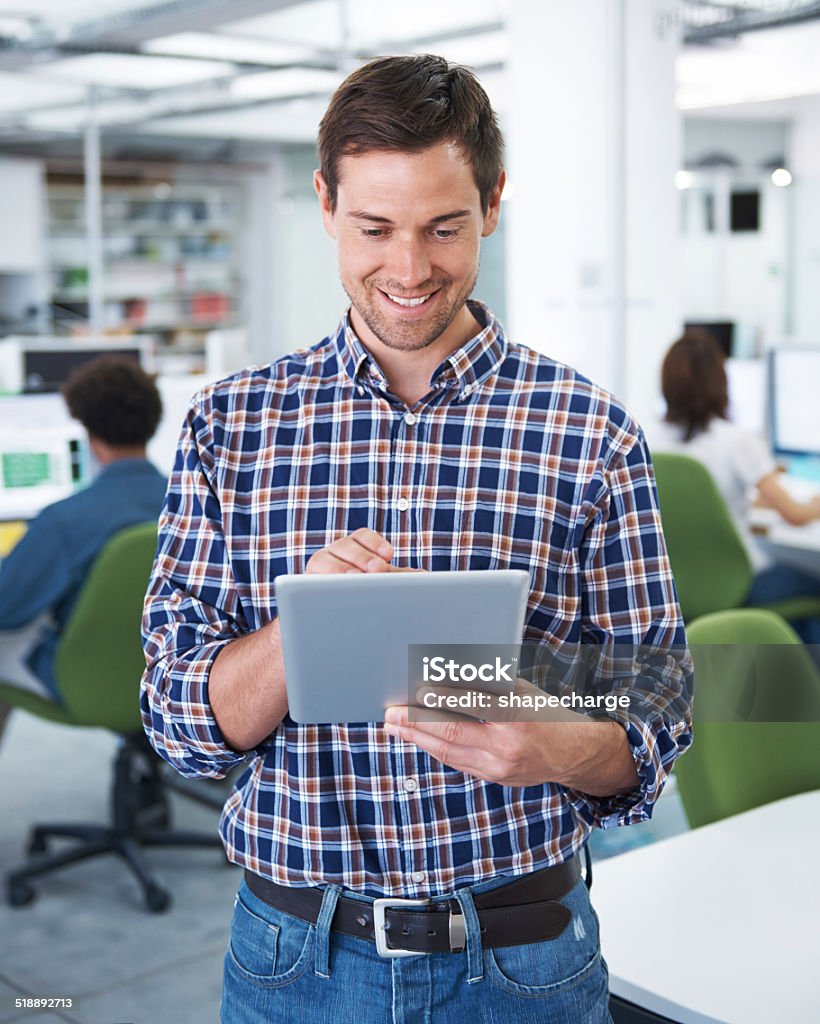 Staying on top of those emails Shot of a young designer using a digital tablet in the office Adult Stock Photo