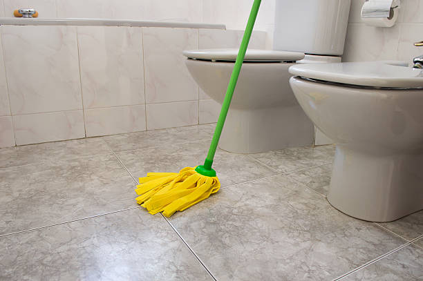 istock scrubbing bathroom with a mop yellow 518892953