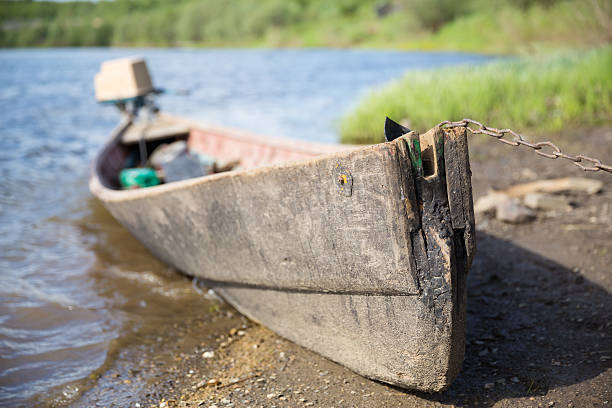 istock bow of boat with motor on shore 518893241
