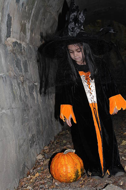 istock Witch child with a pumpkin on Halloween 518895885