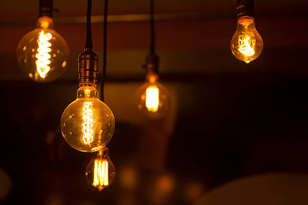 istock illumination by glowing round bulb tungsten lamps on dark background 518897497