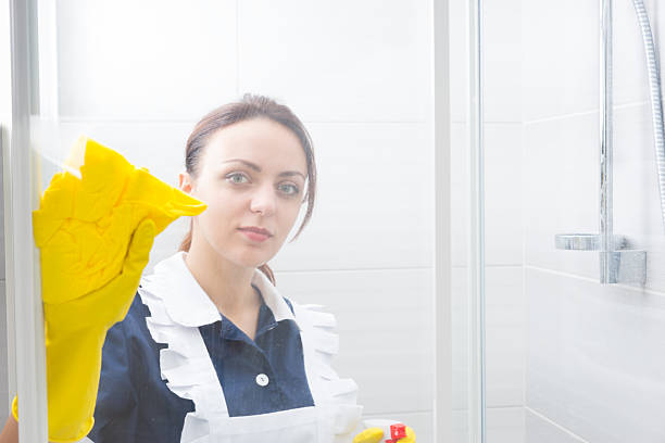istock Attractive housekeeper or maid cleaning a shower 518897650