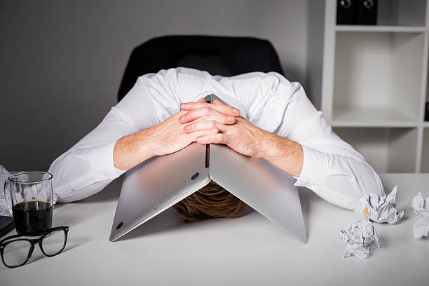 Man hiding under laptop Man hiding under laptop headache photos stock pictures, royalty-free photos & images