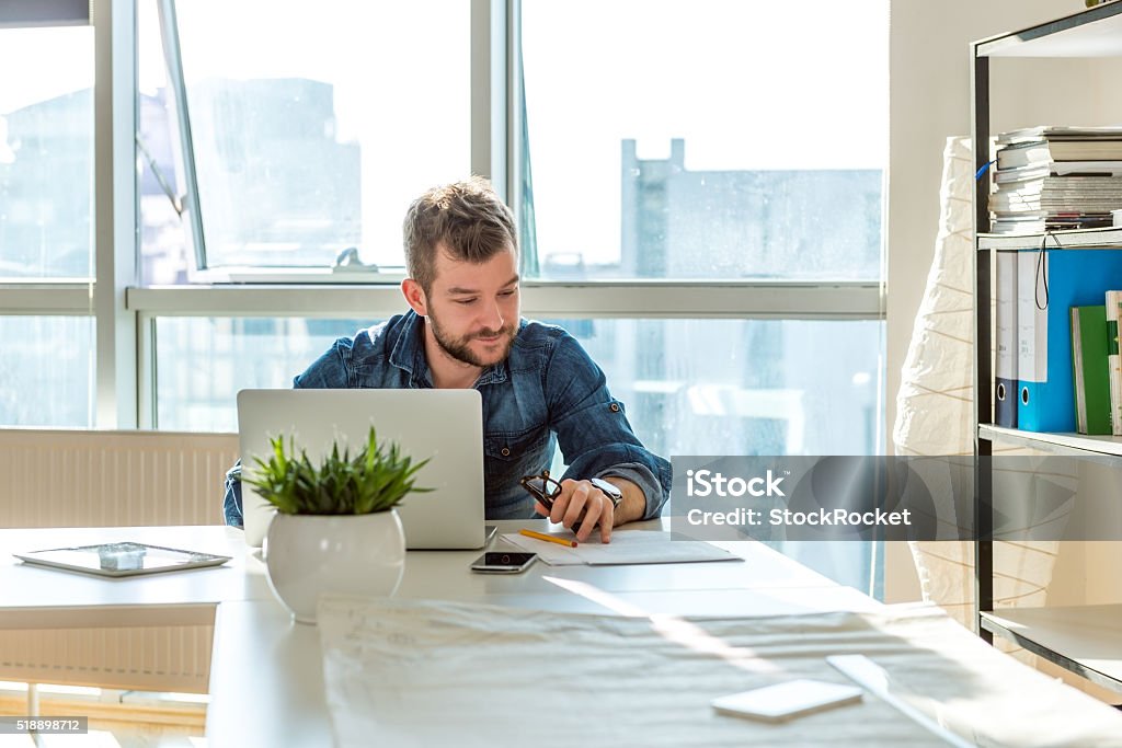 Young man working on laptop Young hipster working on laptop Adult Stock Photo