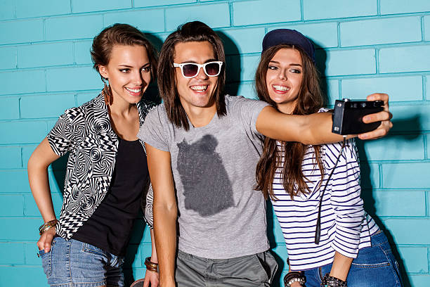 istock Young people with photo camera in front of blue wall 518901368