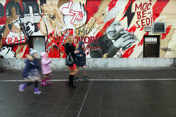 madre e 3 bambini passa da parete colorata graffitti - poster wall blank urban scene foto e immagini stock