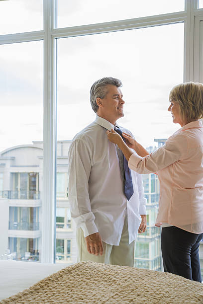istock Wife assisting husband with necktie 518905080