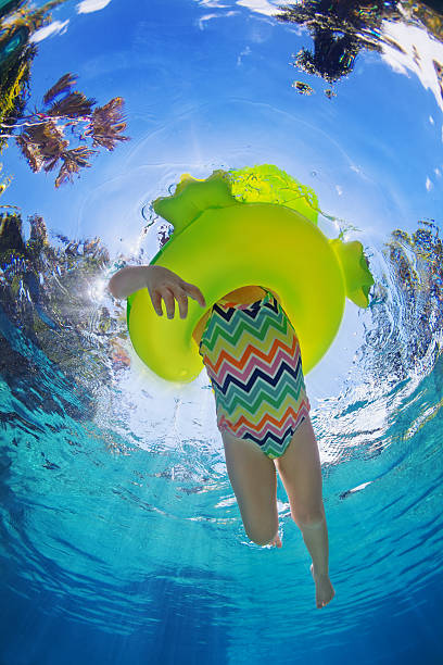 bambino nuoto in piscina gonfiabile tubo giallo - swimming tube inflatable circle foto e immagini stock