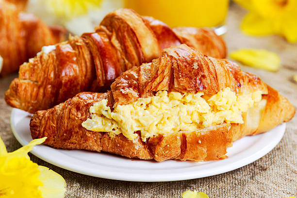 istock Summer Morning Breakfast Croissant stuffed scrambled eggs decorated with flowers. 518909510