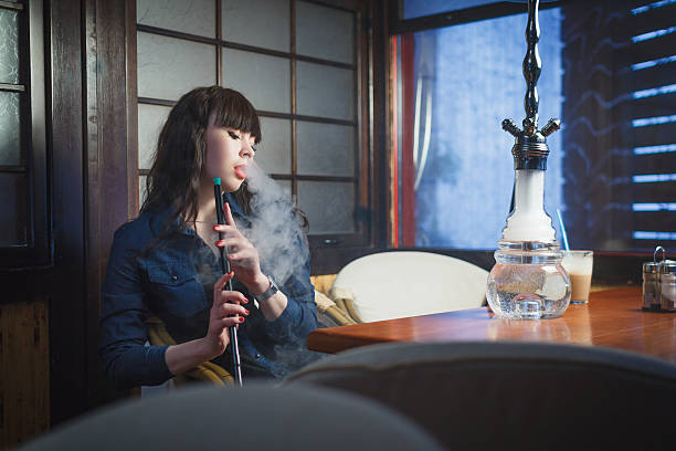 istock Beautiful young woman with hookah 518909514