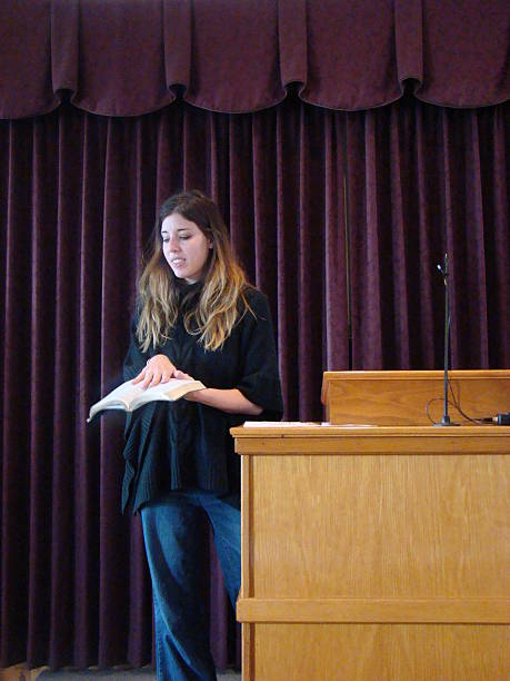 istock woman preaching with hands on the bible 518910273