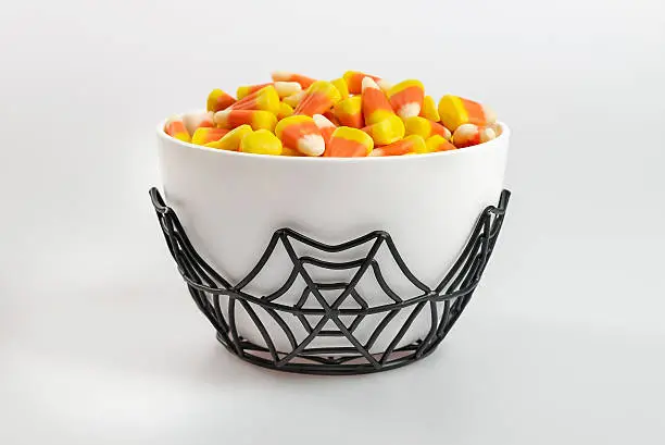 Traditional old fashioned candy corn in a Halloween themed bowl on a white background.  Room for copy space.