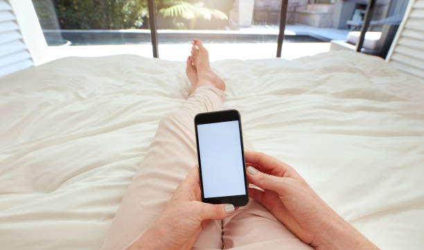 mujer usando teléfono inteligente en la cama - working bed smart phone bedroom fotografías e imágenes de stock