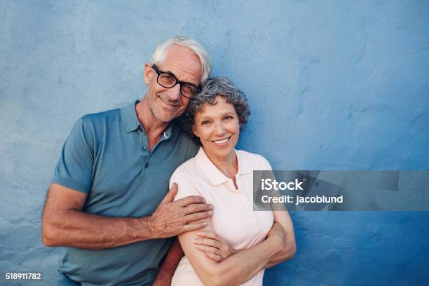 Smiling Mature Couple Standing Together Stock Photo - Download Image Now - Senior Couple, Couple - Relationship, Colored Background