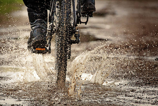 istock Mountain bike splashing through muddy puddle off road 518912073