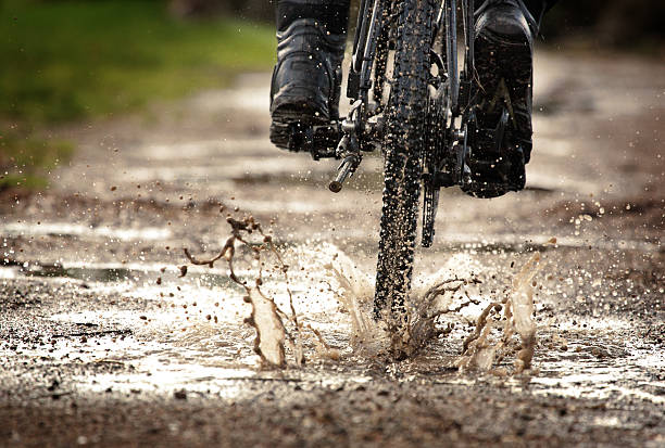 istock Mountain bike splashing through muddy puddle off road 518912089