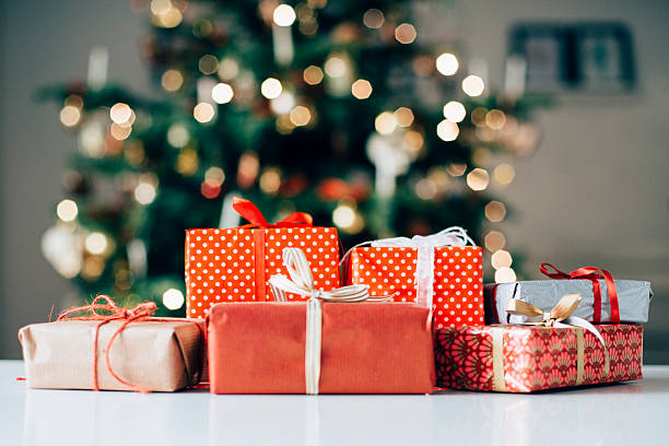 Lots of christmas presents on a table Six different christmas presents is on a table. A christmas tree is in the background. christmas present stock pictures, royalty-free photos & images