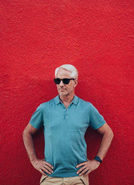istock Stylish mature man posing against red wall 518913248