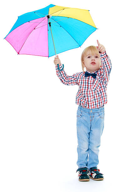 istock Little boy stands under a colorful umbrella. 518913457