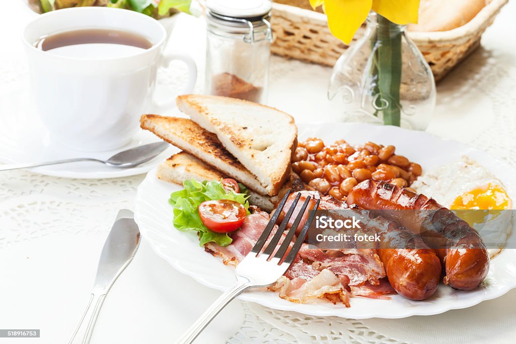 Desayuno inglés completo con tocino, salchichas, huevo frito y horneados - Foto de stock de Al horno libre de derechos