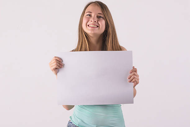 istock cheerful woman holding a white blank banner 518926277