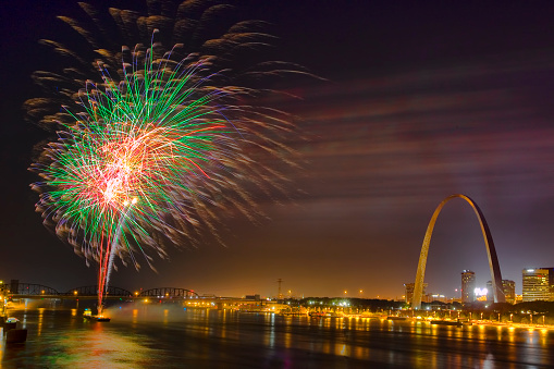 Fourth of July fireworks as seen from the Eads bridge.  Gateway Arch with Mississippi River in foreground.