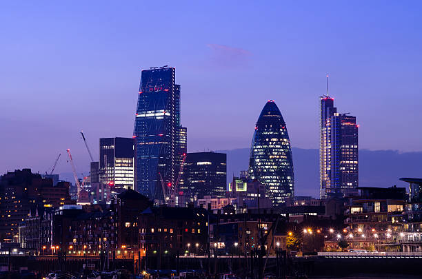 London skyscrapers at night View across the Thames of the skyscrapers of The City of London at dusk. The City is London's tradition banking district and a centre for global finance. Shot includes the Leadenhall Building, informally known as the Cheesegrater. gherkin london night stock pictures, royalty-free photos & images
