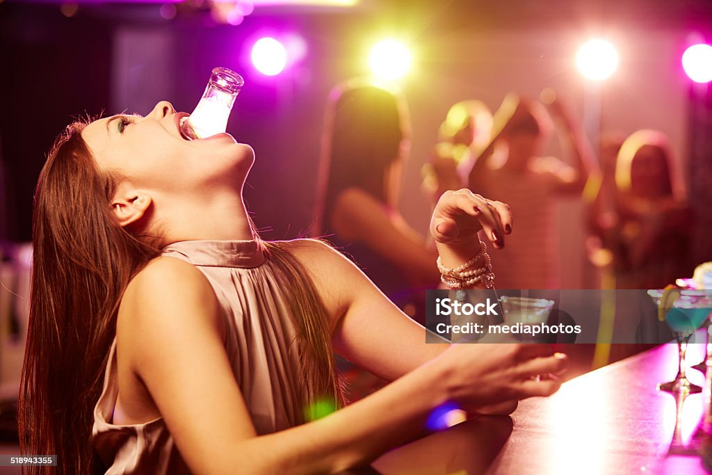 One more shot Young woman drinking shots of tequila at bar counter Drunk Stock Photo