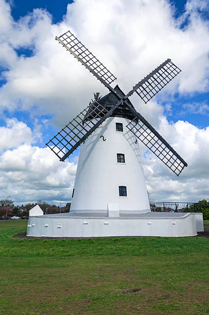 Windmill with black sails and blue sky Windmill with  black sails ,wooden slatted roof against blue sky with fluffy white clouds lytham st. annes stock pictures, royalty-free photos & images