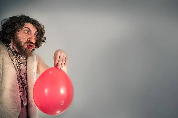 Silly caveman grunts at confusing red birthday balloon