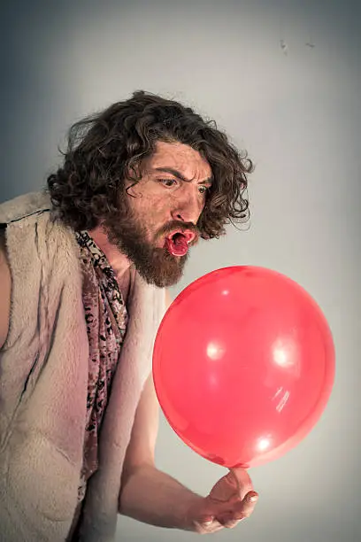 Silly caveman grunts at confusing red birthday balloon