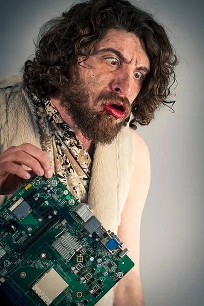 Silly grunting caveman confused by modern computer technology
