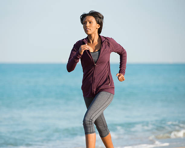 istock Young woman running on the beach. 518949584