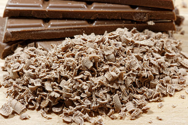 istock Grated chocolate and chocolate bars on wooden plank 518949658