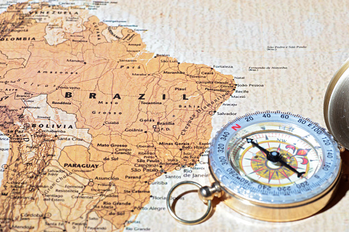 Compass on a map pointing at Brazil, planning a travel destination