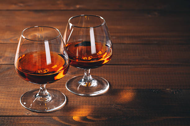 Two glasses of cognac on the wooden table. stock photo