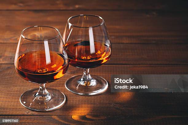 Two Glasses Of Cognac On The Wooden Table Stock Photo - Download Image Now - Brandy, Cognac - Brandy, Drinking Glass