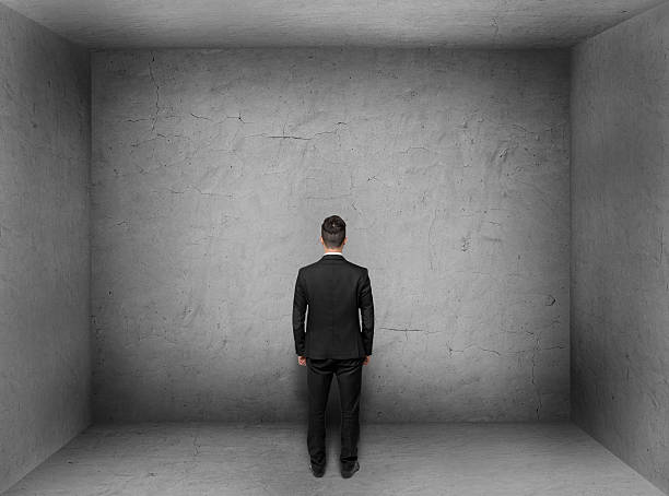 istock Back view of businessman inside empty concrete room 518951290