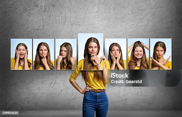 Girl Holds And Changes Her Face Portraits With Different Emotions Stock Photo - Download Image Now