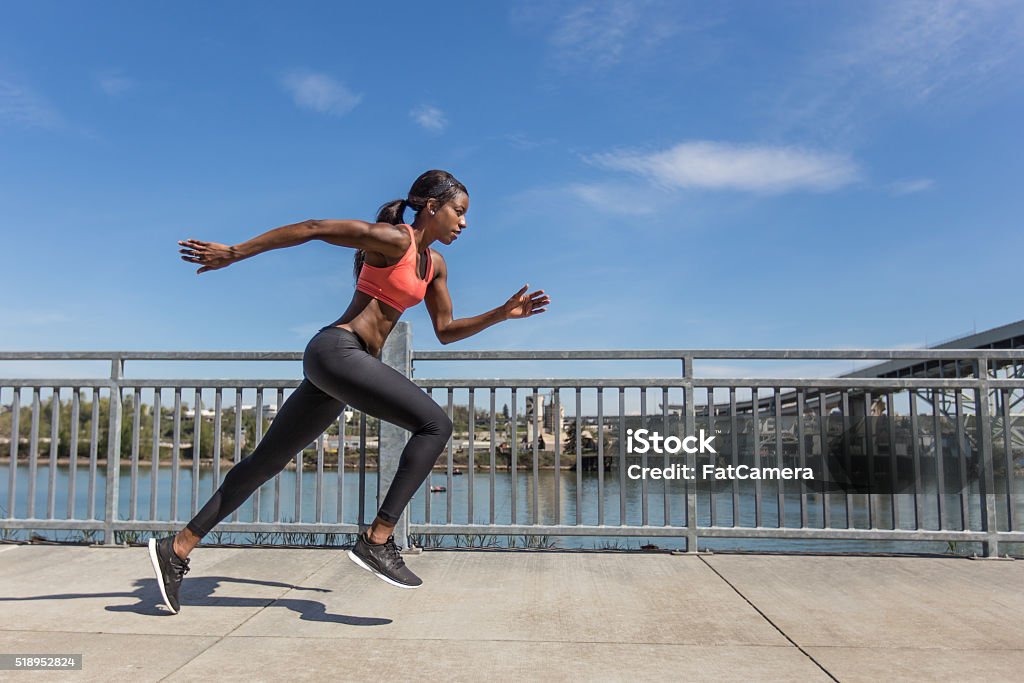 Attractive ethnic female sprinter training in the city Women Stock Photo