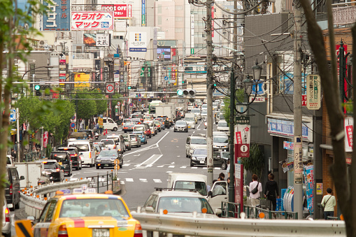 Tokyo, Japan - April 28 2014: A typical busy day at Kasugadori Road in Bunkyo, Tokyo. Cars are jamming up and people are making their way to nearby shopping and entertainment areas on a warm spring afternoon.