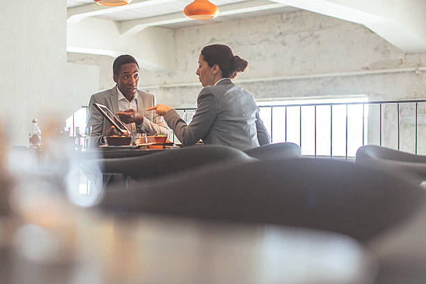 仕事一色と若い男性が、ビジネスラウンジでレストラン - two people business lunch multi ethnic group meeting ストックフォトと画像