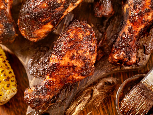 Jerk Chicken with Corn BBQ Grilled Jerk Chicken and Corn- Photographed on Hasselblad H3D2-39mb Camera cajun food photos stock pictures, royalty-free photos & images