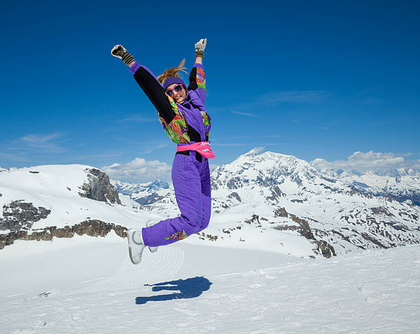 Cheerful young woman jump on snow at wonderful winter day on mountain