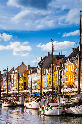 Nyhavn canal with its colorful houses on a clear day with blue sky in Copenhagen, Denmark