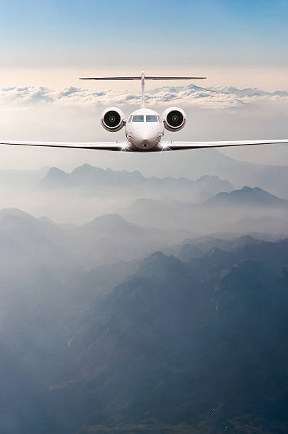 Airplane fly over clouds and Alps mountain on sunset. Front