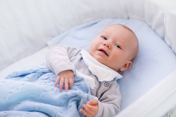 istock Baby boy in a crib under knitted blanket 518962534