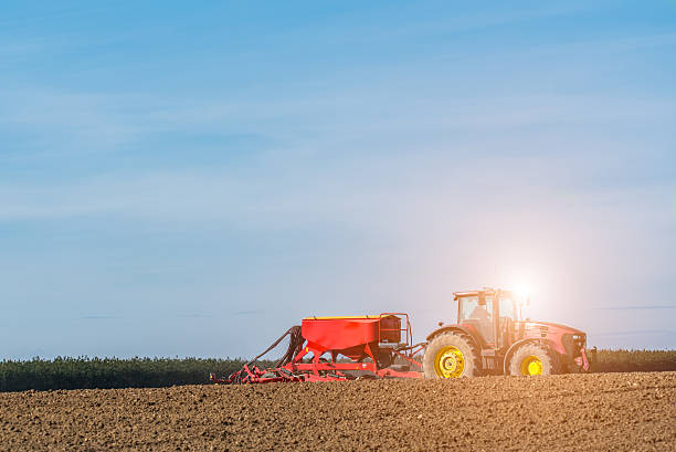 istock Sunset above the tractor harrowing the field 518963546