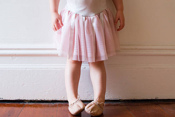 Toddler in pink tutu Toddler in pink tutu and ballet shoes standing in vintage hallway (cropped) ballet dancer feet stock pictures, royalty-free photos & images
